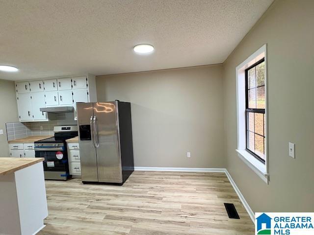 kitchen featuring white cabinetry, plenty of natural light, stainless steel appliances, and light wood-type flooring