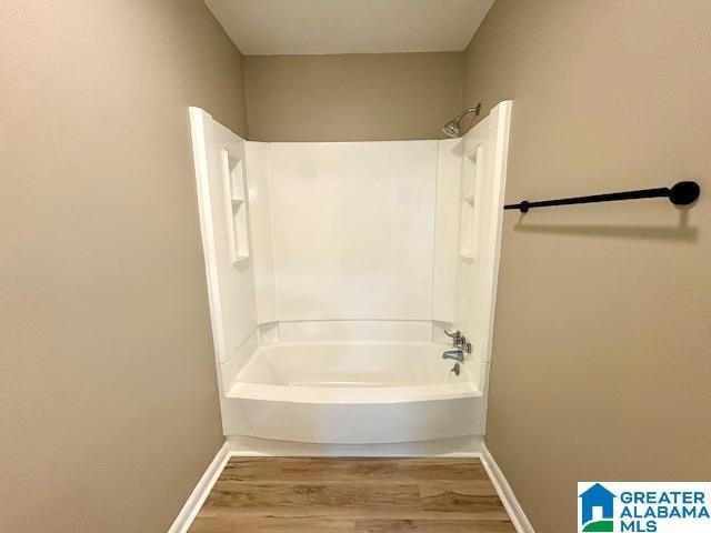 bathroom with shower / bathing tub combination and hardwood / wood-style flooring