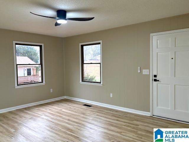 spare room featuring ceiling fan, a textured ceiling, and light hardwood / wood-style flooring