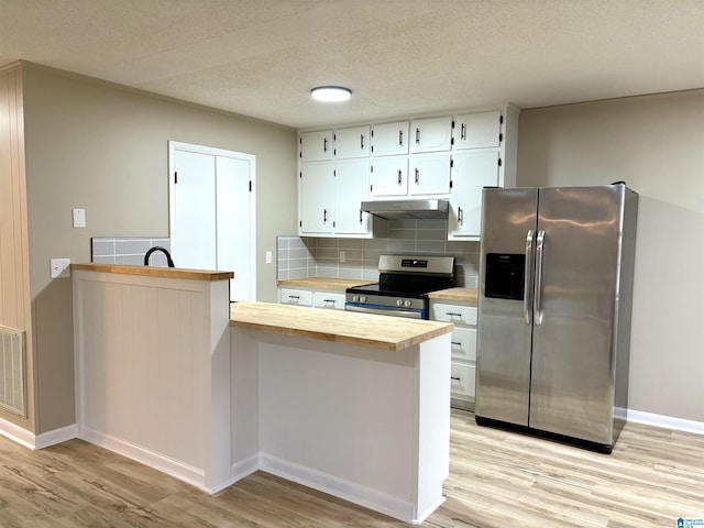 kitchen with white cabinets, stainless steel appliances, light hardwood / wood-style flooring, and tasteful backsplash