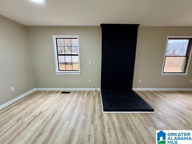 spare room featuring light hardwood / wood-style floors and a textured ceiling