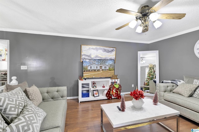 living room with crown molding, dark hardwood / wood-style flooring, ceiling fan, and a textured ceiling