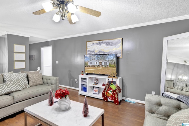 living room with ceiling fan, ornamental molding, a textured ceiling, and dark wood-type flooring