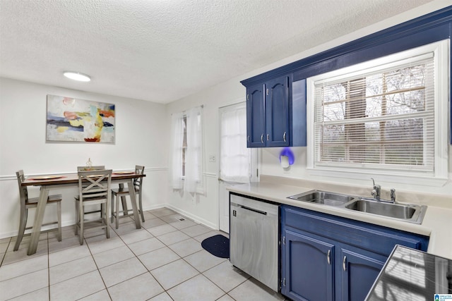 kitchen featuring a textured ceiling, blue cabinets, sink, light tile patterned floors, and dishwasher