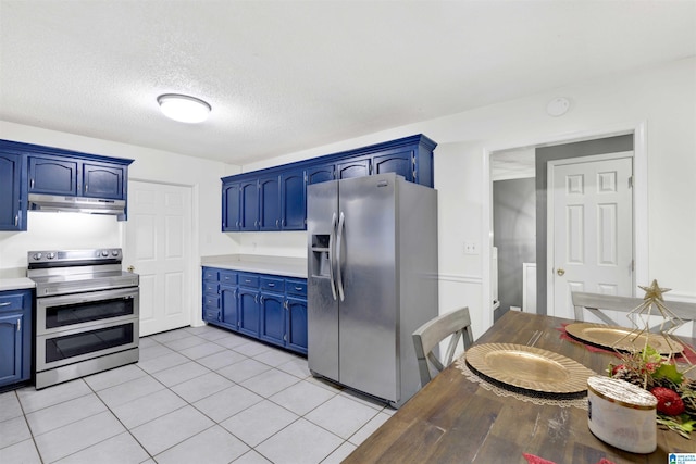 kitchen with blue cabinetry, light tile patterned flooring, a textured ceiling, and appliances with stainless steel finishes