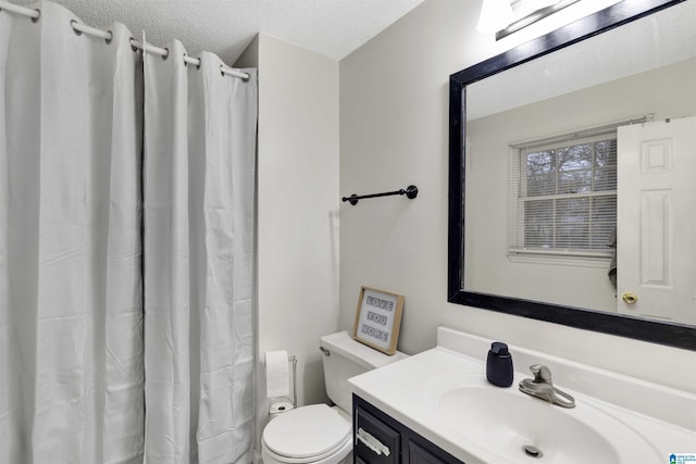 bathroom with vanity, a textured ceiling, and toilet