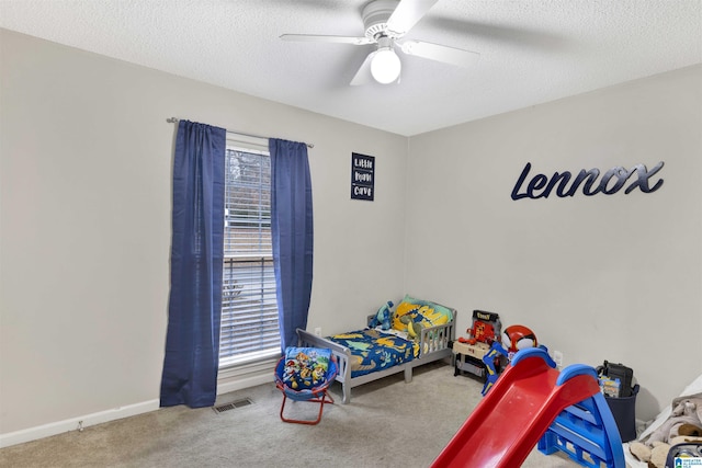 bedroom with carpet flooring, a textured ceiling, multiple windows, and ceiling fan