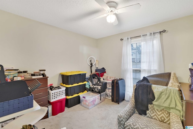 game room with light carpet, ceiling fan, and a textured ceiling