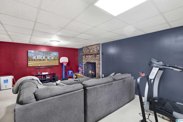 carpeted living room with a fireplace and a drop ceiling