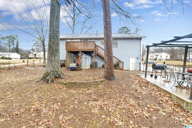 rear view of house featuring a pergola and a deck