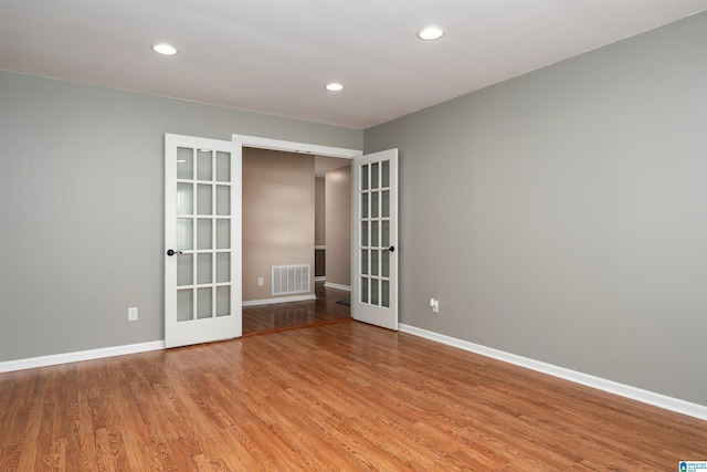 spare room with french doors and light hardwood / wood-style floors