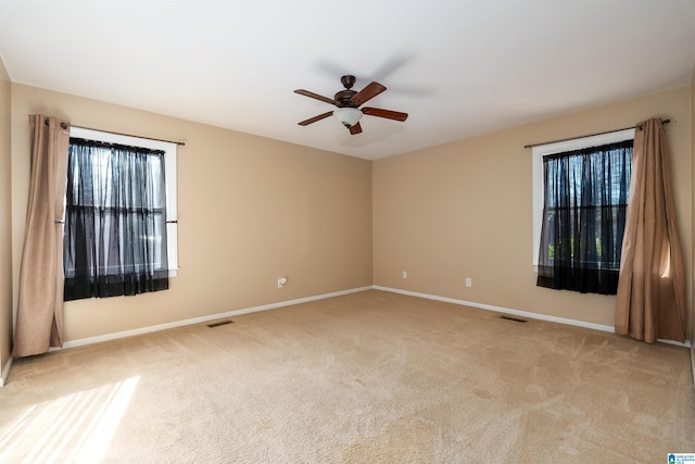 empty room with ceiling fan and light colored carpet