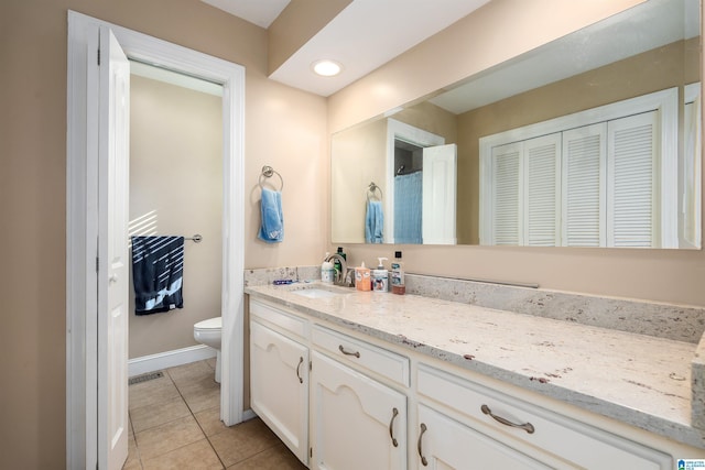 bathroom featuring tile patterned flooring, vanity, and toilet