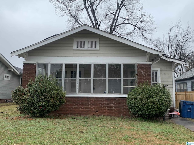 view of property exterior featuring a yard and a sunroom