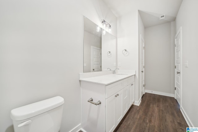 bathroom with hardwood / wood-style floors, vanity, and toilet