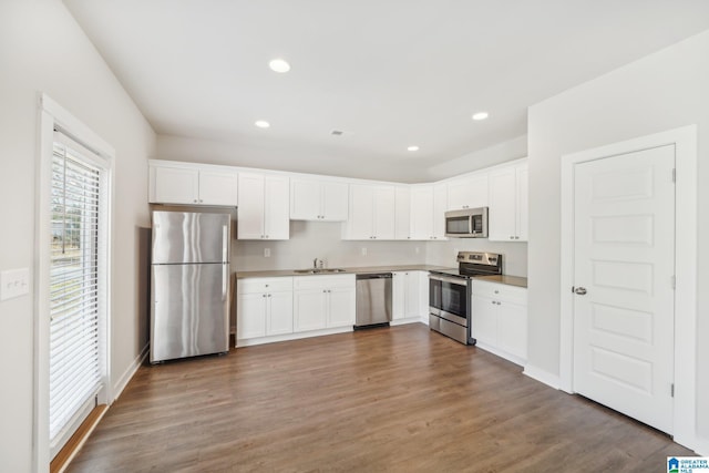 kitchen featuring sink, white cabinets, stainless steel appliances, and dark hardwood / wood-style floors