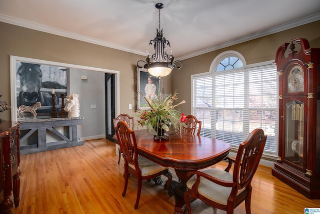 dining space with light hardwood / wood-style floors and ornamental molding