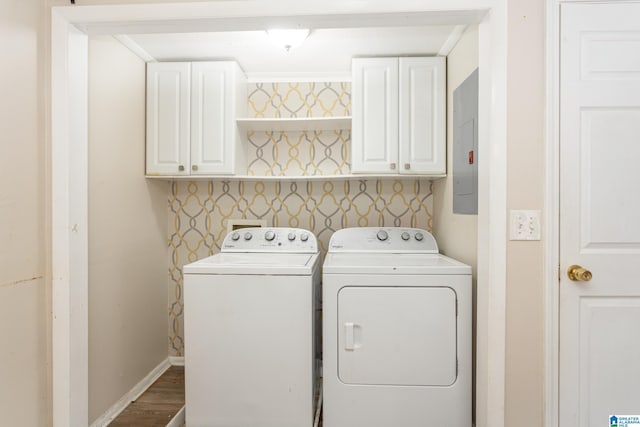 washroom with washing machine and clothes dryer, electric panel, cabinets, and hardwood / wood-style flooring