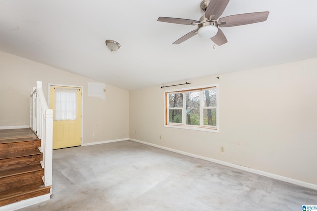 spare room featuring light carpet, vaulted ceiling, and ceiling fan