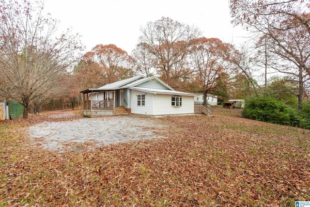 view of side of property featuring covered porch