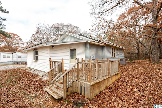 rear view of house featuring central air condition unit and a deck