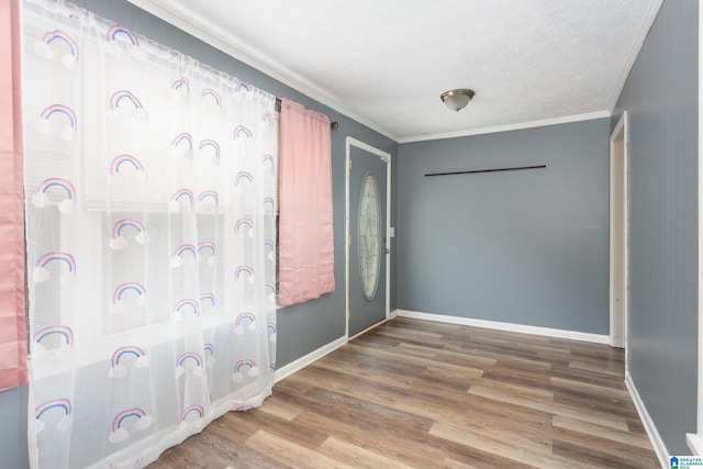 interior space with a textured ceiling, hardwood / wood-style flooring, and crown molding