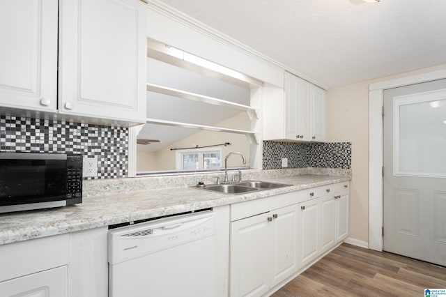 kitchen featuring sink, white dishwasher, light hardwood / wood-style floors, decorative backsplash, and white cabinets