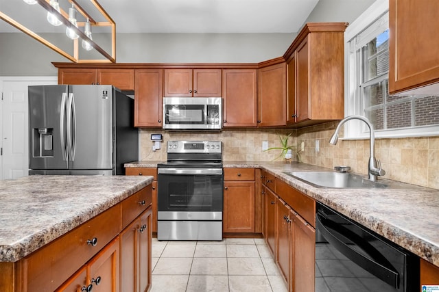 kitchen featuring sink, backsplash, decorative light fixtures, light tile patterned flooring, and appliances with stainless steel finishes