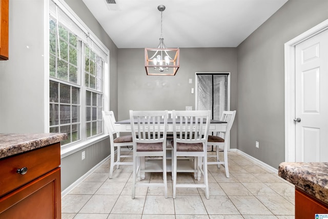 dining room featuring a notable chandelier, light tile patterned floors, and a wealth of natural light