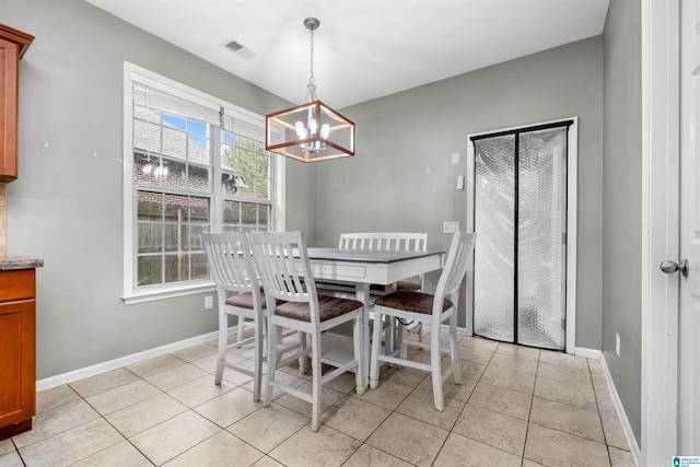 dining space featuring an inviting chandelier and light tile patterned flooring