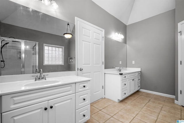 bathroom with tile patterned floors, vanity, vaulted ceiling, and walk in shower