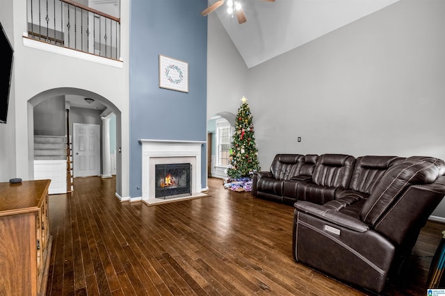 living room with dark hardwood / wood-style floors, high vaulted ceiling, and ceiling fan