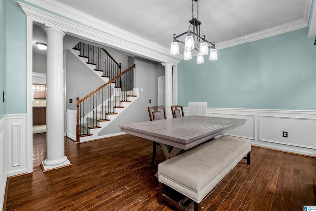 dining room featuring a notable chandelier, ornamental molding, dark wood-type flooring, and decorative columns