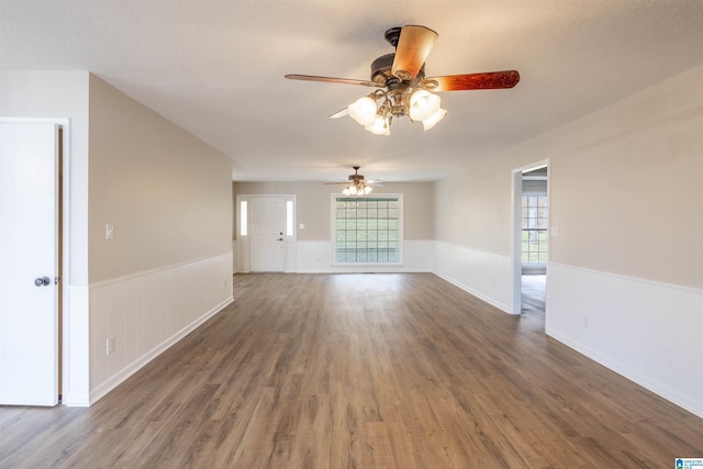 spare room with dark hardwood / wood-style floors, ceiling fan, and a healthy amount of sunlight