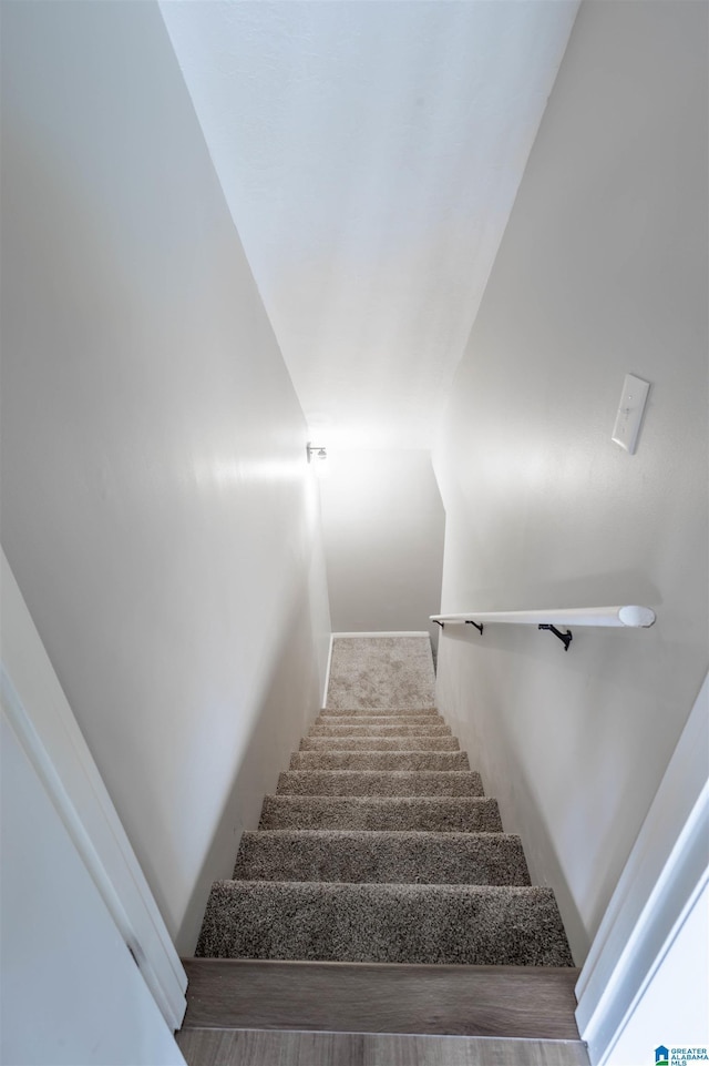 staircase featuring hardwood / wood-style floors and vaulted ceiling