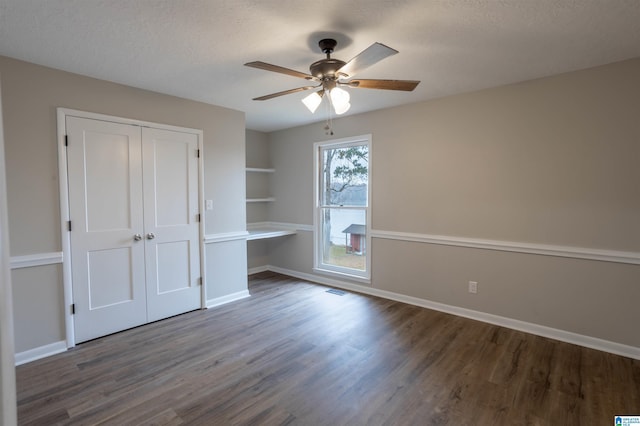 unfurnished bedroom with a textured ceiling, a closet, ceiling fan, and dark wood-type flooring