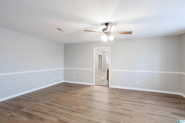 spare room with a textured ceiling, hardwood / wood-style flooring, and ceiling fan