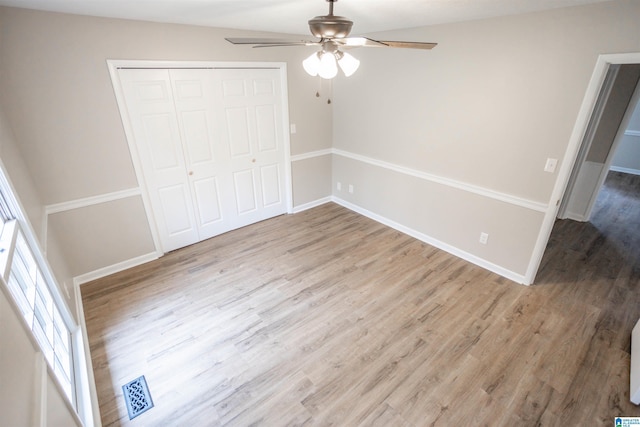 unfurnished bedroom with ceiling fan, a closet, and light hardwood / wood-style floors