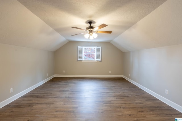 bonus room with dark hardwood / wood-style floors, ceiling fan, a textured ceiling, and vaulted ceiling