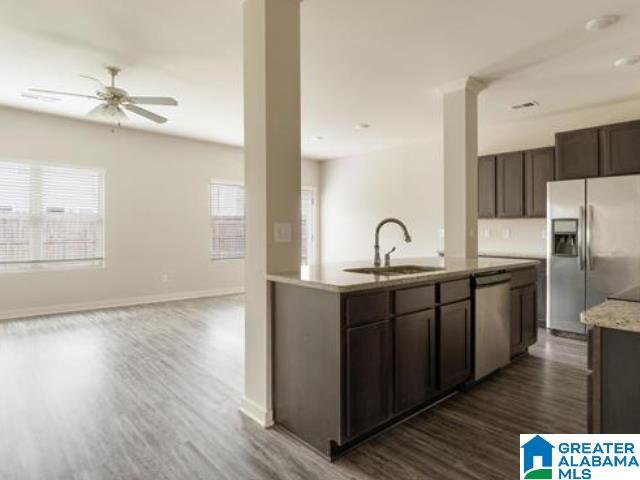 kitchen with dark wood-type flooring, stainless steel appliances, a healthy amount of sunlight, and sink