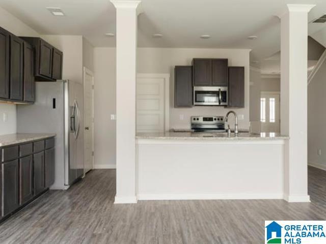 kitchen with sink, dark brown cabinetry, light wood-type flooring, and stainless steel appliances