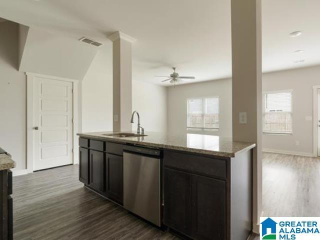 kitchen featuring dishwasher, sink, ceiling fan, light stone counters, and dark hardwood / wood-style flooring