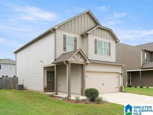 craftsman inspired home with a garage, a front lawn, and central air condition unit