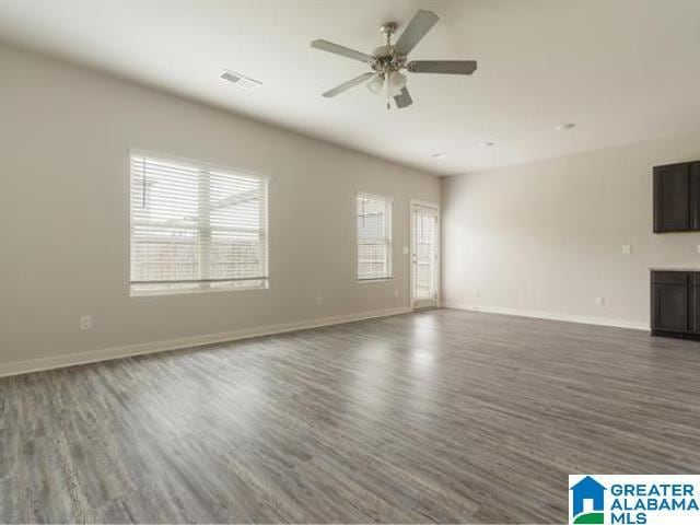 unfurnished living room with ceiling fan and dark hardwood / wood-style floors