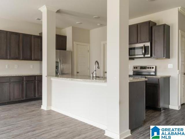 kitchen featuring appliances with stainless steel finishes, sink, dark brown cabinets, and hardwood / wood-style floors