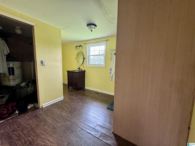 corridor featuring electric water heater and dark wood-type flooring