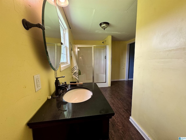 bathroom with vanity, hardwood / wood-style flooring, and a shower with door