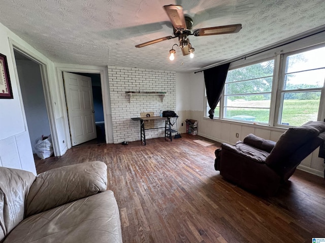 living room with ceiling fan, hardwood / wood-style floors, and a textured ceiling