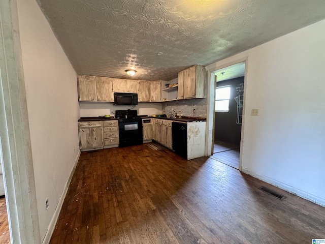 kitchen featuring dark hardwood / wood-style flooring, black appliances, and a textured ceiling