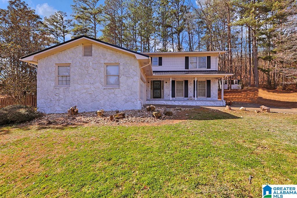 view of front of home with a porch and a front lawn